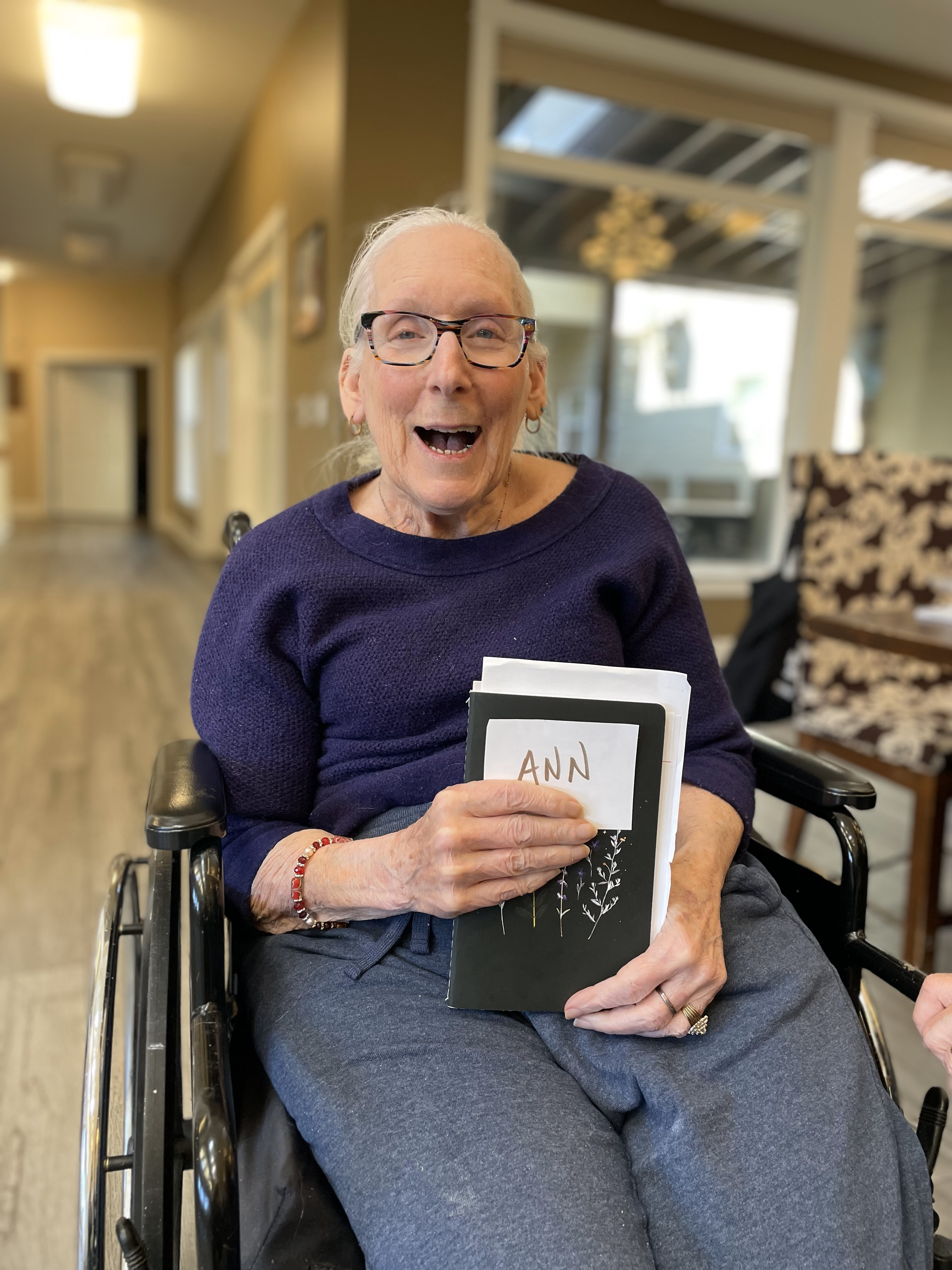 A participant shows her journal and smiles.